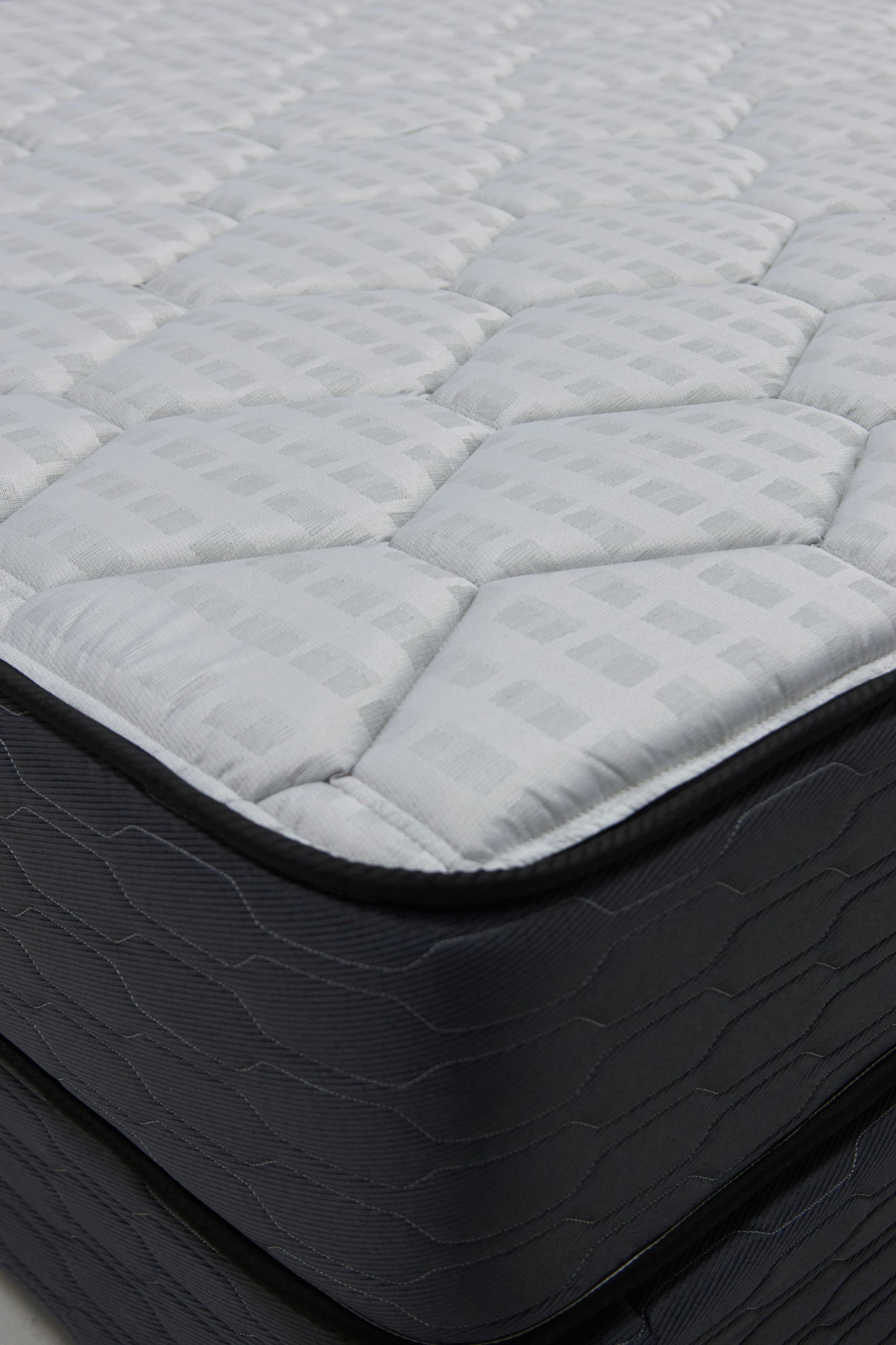 Close-up of a quilted mattress with dark sides